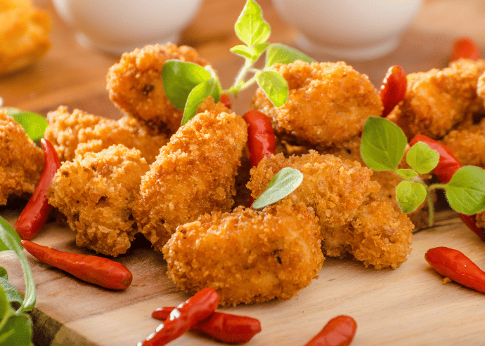 Bolitas de maíz rellenas de papa y queso en salsa roja