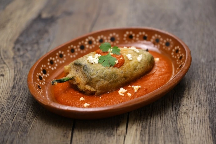 Chiles poblanos rellenos de huitlacoche, camarón y elote con salsa de chile ancho